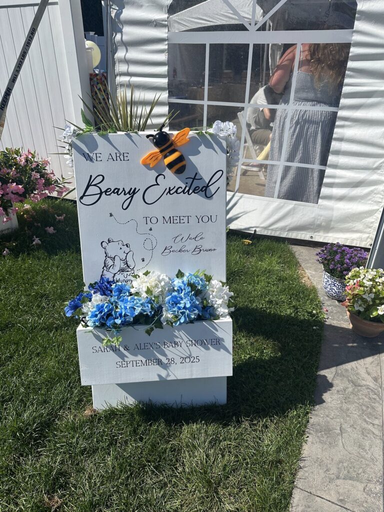 A baby shower welcome sign with a hand-drawn bear on it
