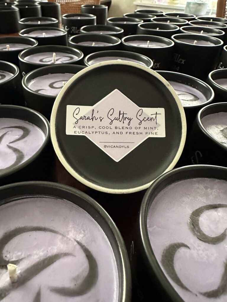 A candle tin labelled with a custom scent name and notes