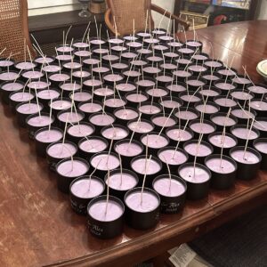 A table covered with around a hundred poured pink candles