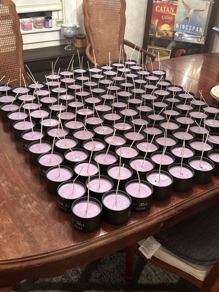 A table covered with around a hundred poured pink candles