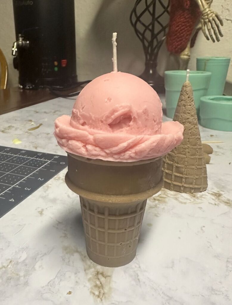 A candle shaped like a scoop of ice cream on a waffle cone