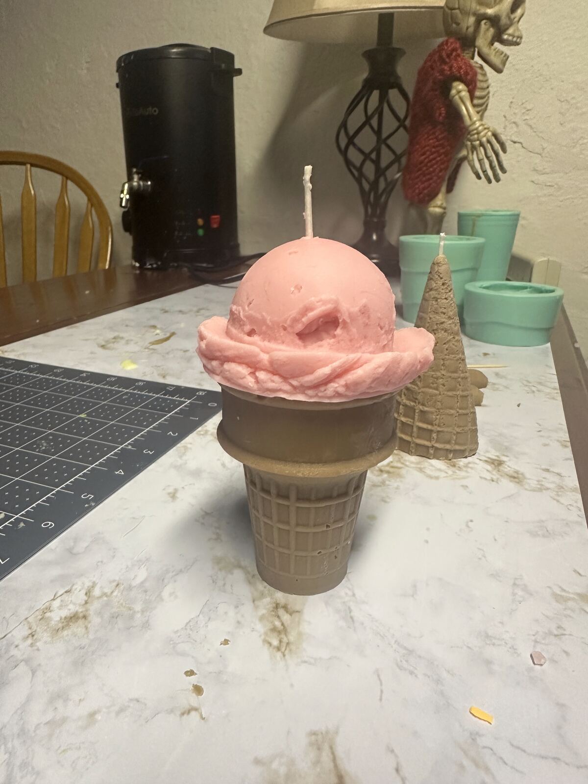 A candle shaped like a scoop of ice cream on a waffle cone