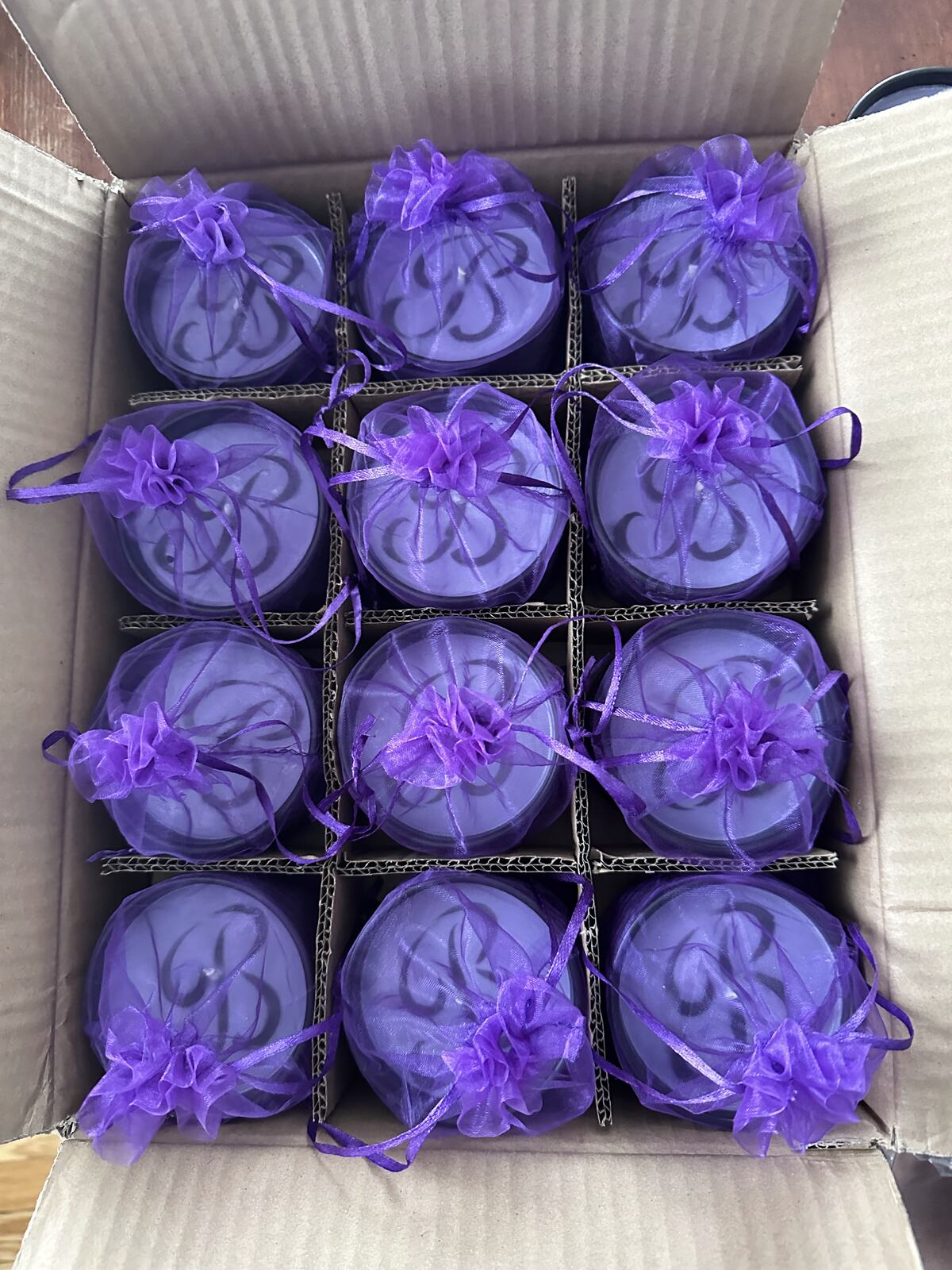 Purple organza favour bags packed in a shipping box