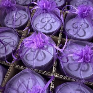 Monogrammed candle tins in purple organza favor bags