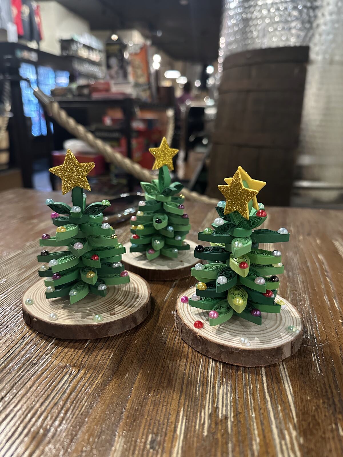 Small Christmas trees built from fused perler beads on wood slices