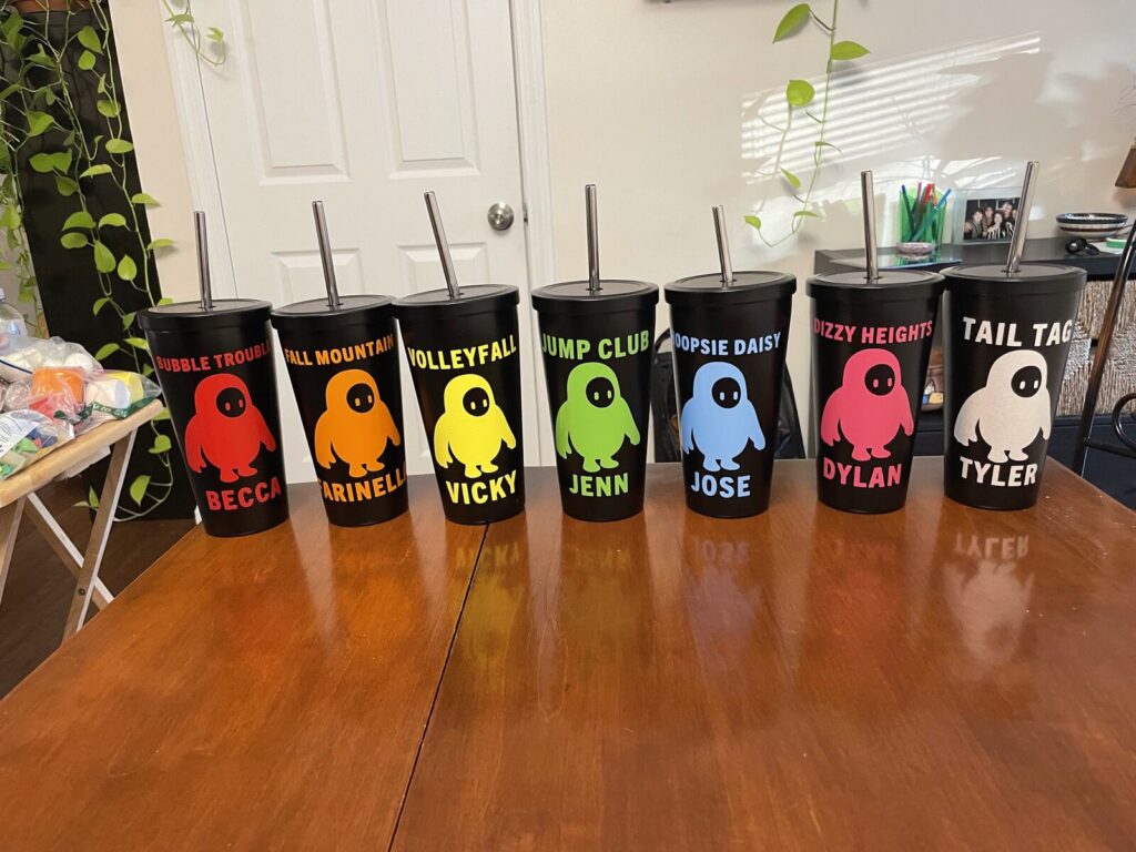 A row of coloured tumblers each printed with a different name and nickname