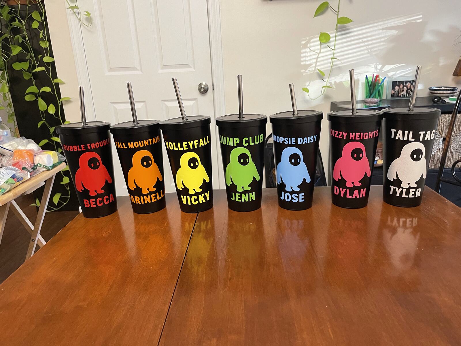 A row of coloured tumblers each printed with a different name and nickname