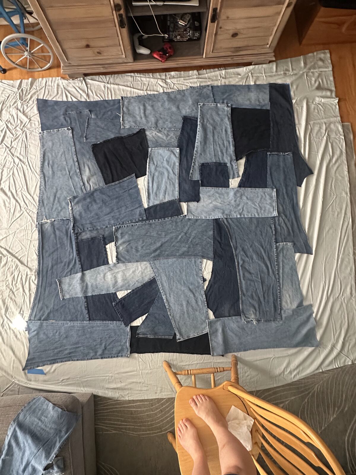 Grey and white quilt blocks laid out on a bed before piecing