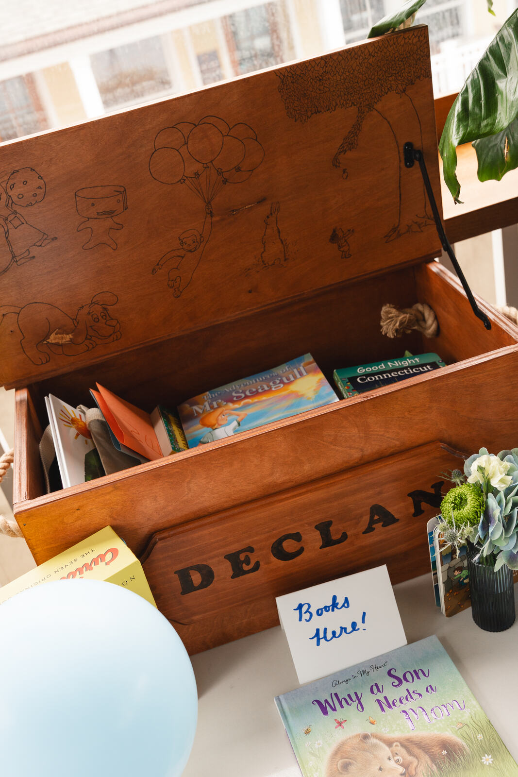 The woodburned toy box open and filled with children's books