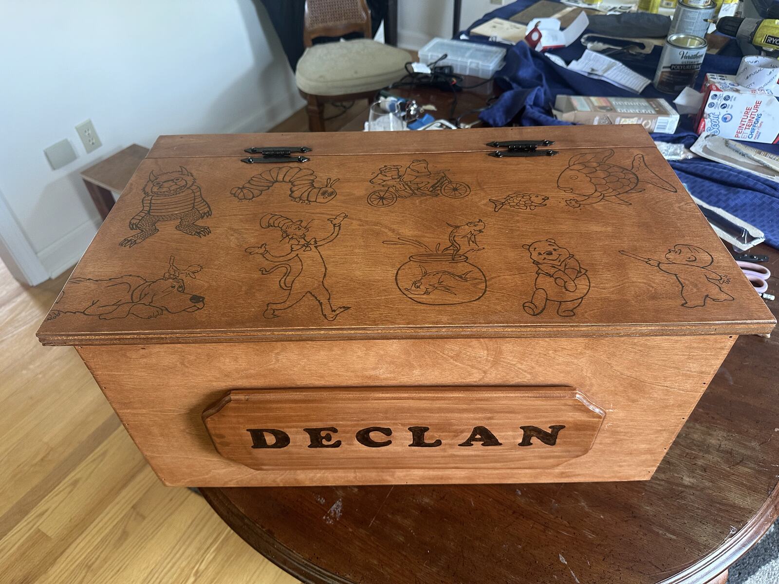A wooden toy box woodburned with a child's name and storybook animals
